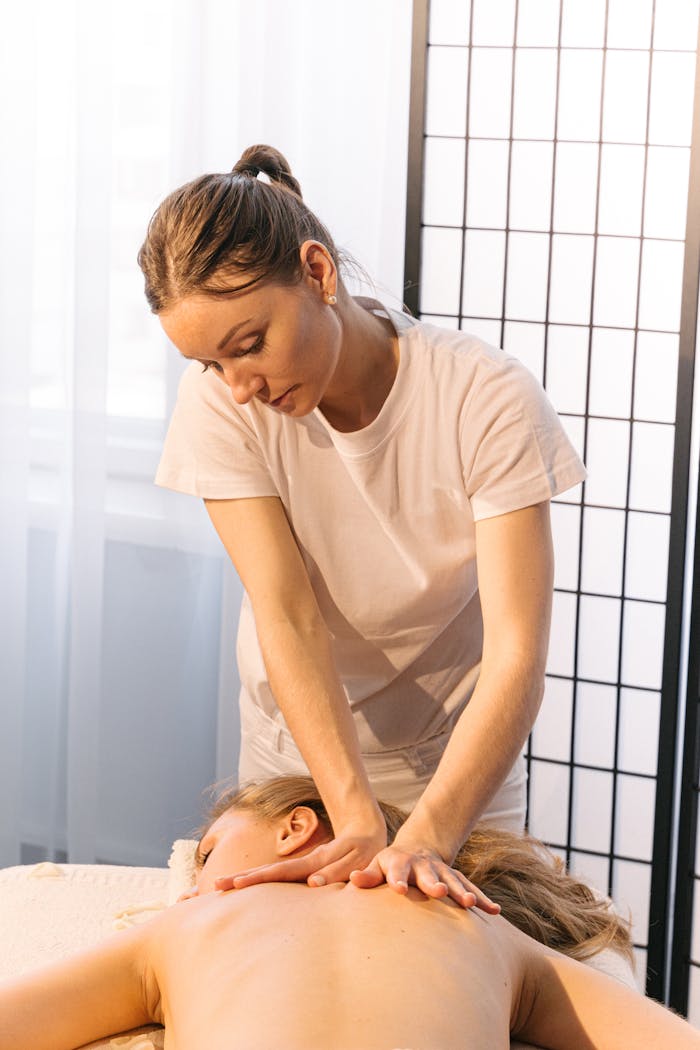 about-01 Experienced masseuse providing a relaxing back massage in a tranquil spa setting.
